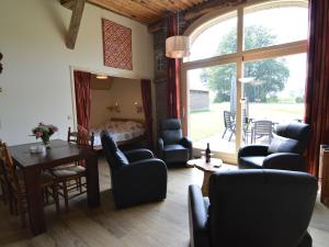 GeesterenにあるQuaint Farmhouse in Geesteren with Meadow Viewのリビングルーム(椅子、テーブル付)、ベッドルーム1室が備わります。