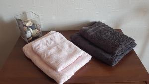 two towels and a vase on a wooden table at Artbnb in Lézat-sur-Lèze