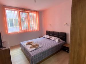 a bedroom with a bed with two towels on it at Apartamenti Ely in Pomorie