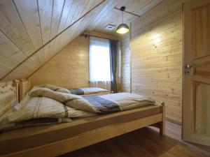 a bedroom with two beds in a wooden room at Wooden Holiday Home in Skrzynia with Terrace in Osiek