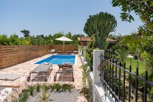 a backyard with a swimming pool and a fence at Elli's apartment 1 in Antimácheia