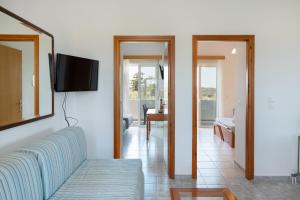 a living room with a couch and a tv on a wall at Elli's apartment 1 in Antimácheia