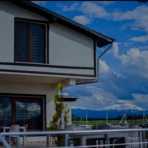a house with a balcony with a view of the mountains at Meriç butik otel 