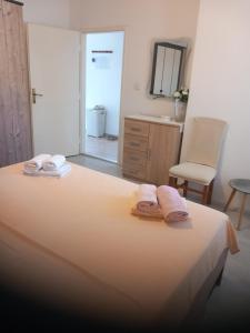 a bedroom with a bed with two towels on it at Vila Neve 87 Apartman in Veliko Brdo