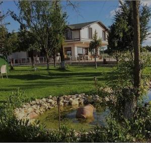 a home with a pond in front of a house at Meriç butik otel 