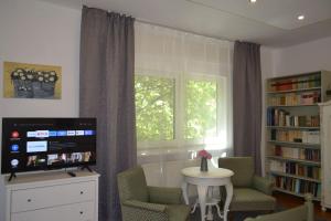 un salon avec une table et des chaises et une fenêtre dans l'établissement New Vintage house with Netflix Füge és könyvtár, à Keszthely 16 autres photos