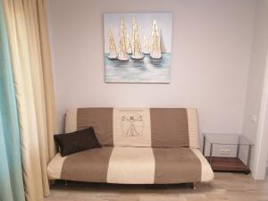 a couch in a living room with a painting on the wall at Jurmala Kauguri in Jūrmala