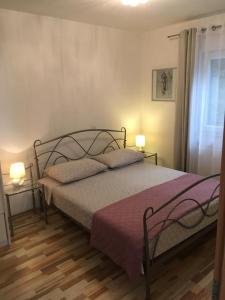 - une chambre avec un lit et 2 oreillers dans l'établissement Apartments Salona, à Trogir
