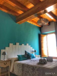 1 dormitorio con 1 cama grande y paredes verdes en Ekhiola, en Ochagavía