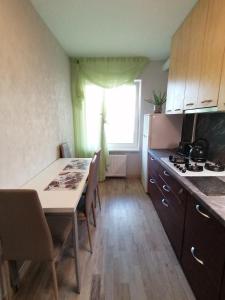 a kitchen with a table with chairs and a window at Jurmala Kauguri in Jūrmala +33 photos