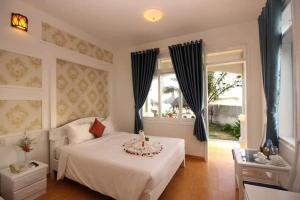 a bedroom with a white bed and a window at Muine Sun & Sea Resort in Mui Ne