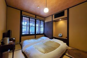 a bedroom with a large bed and a window at Itsukushimahigashimonzen Kikugawa in Miyajima