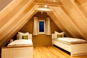 two beds in a room with an attic at Ferienwohnung Herrmanns Häuser - Leipziger Neuseenland in Rötha