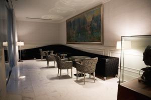 un comedor con mesas, sillas y una pintura en Hotel Balneari Termes Orion, en Santa Coloma de Farners