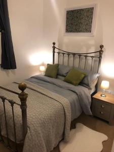 a bed with two green pillows in a bedroom at Fusilier apartment wrexham city in Wrexham