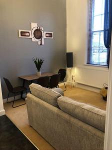 Fusilier apartment wrexham city في ريكسهام: غرفة معيشة مع أريكة وطاولة