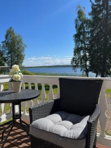 Vikajärvi Lake View Experience Igloos في روفانييمي: كرسي الخوص الجلوس على شرفة مع طاولة