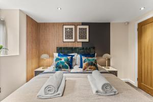 a bedroom with a large bed with blue pillows at Stunning Church Conversion Apartment in Sheffield