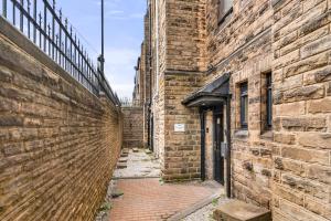 an alley way between two brick buildings at Spacious & Modern 2 Bedroom Flat in Sheffield in Sheffield