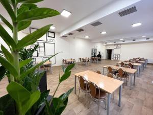 a room with tables and chairs and a plant at Kompleks Hotelowo-Rekreacyjny “Kasztelanka” in Ciechocinek