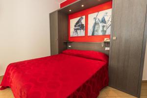 Cette chambre comprend un lit rouge avec un couvre-lit rouge. dans l'établissement Kiara Residence, à Giulianova