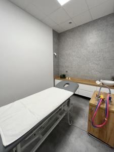 a hospital room with a bed and a sink at Kompleks Hotelowo-Rekreacyjny “Kasztelanka” in Ciechocinek
