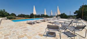 a group of chairs and tables next to a pool at Masseria Puglia Antica in Monopoli