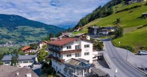budynek na wzgórzu obok drogi w obiekcie Pitztal Living Apartments w mieście Jerzens