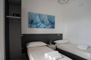 twee bedden in een kamer met een foto aan de muur bij Villa Angeline 