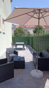 a patio with an umbrella and a table and chairs at Aserradero - Bajo con terraza y piscina ! in San Martín de Arriba