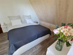 a bedroom with a bed and a vase of flowers at Apartment Einssein Bergfried - mit Weitblick in Dettingen unter Teck