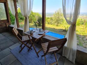 a wooden table and chairs on a porch with a view at Apartment Einssein Bergfried - mit Weitblick in Dettingen unter Teck