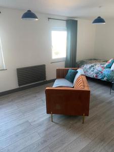 uma sala de estar com um sofá e uma cama em Torpoint Pod - Free Parking em Torpoint