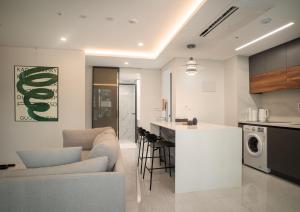 a living room and a kitchen with a couch and a counter at UH FLAT The Seocho in Seoul