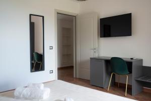 een kamer met een bureau, een spiegel en een stoel bij Villa Angeline 