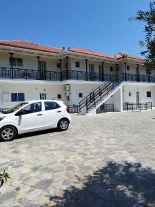 un coche blanco estacionado frente a un edificio en VILLA AGIA AIKATERINI en Amoudi