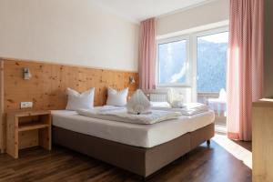 sypialnia z łóżkiem i dużym oknem w obiekcie Pitztal Living Apartments w mieście Jerzens