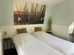 2 letti posti uno accanto all'altro in una stanza di Hotelhuisjes Oosterleek a Oosterleek