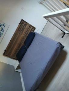 a blue pillow sitting on top of a bed at Particulier in Palavas-les-Flots