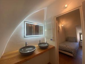 ein Bad mit zwei Waschbecken und einem Bett in der Unterkunft Entre Tarn et Causses in Le Recoux