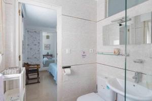 a white bathroom with a sink and a toilet at Caleta del Sol con piscina terraza y playa in Caleta De Velez
