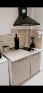 a kitchen with a sink and a black hood at Un temps pour soi in Châteauroux