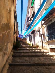 an alley with stairs and blue lights in a city at La casetta di Carmela in Naples