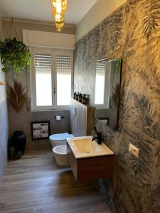 ein Bad mit einem Waschbecken und einem WC in der Unterkunft TROPICAL HOME PORTO CERESIO in Porto Ceresio