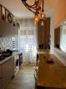 eine Küche mit einem Holztisch in einer Küche mit einer Waschmaschine in der Unterkunft TROPICAL HOME PORTO CERESIO in Porto Ceresio