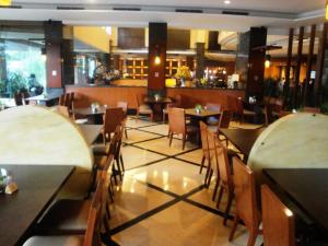 a dining room with tables and chairs in a restaurant at Manado Quality Hotel in Manado