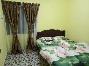 ein Schlafzimmer mit einem Bett mit Blumen darauf in der Unterkunft La' Homestay in Kota Bharu