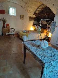 een slaapkamer met een bed en een tafel in een kamer bij Magnanerie du Perrier : studio indépendant au pied des Cévennes in Pompignan