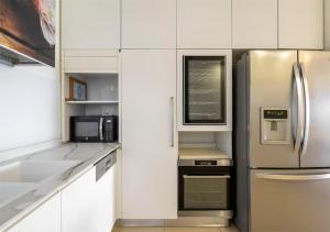 a kitchen with a stainless steel refrigerator and a microwave at Yama SEA VIEW 4BR in Nahariyya