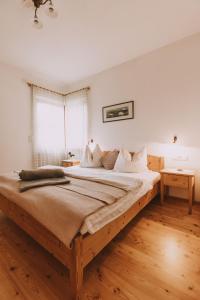 a large bed in a bedroom with a wooden floor at Weinberghof in Appiano sulla Strada del Vino